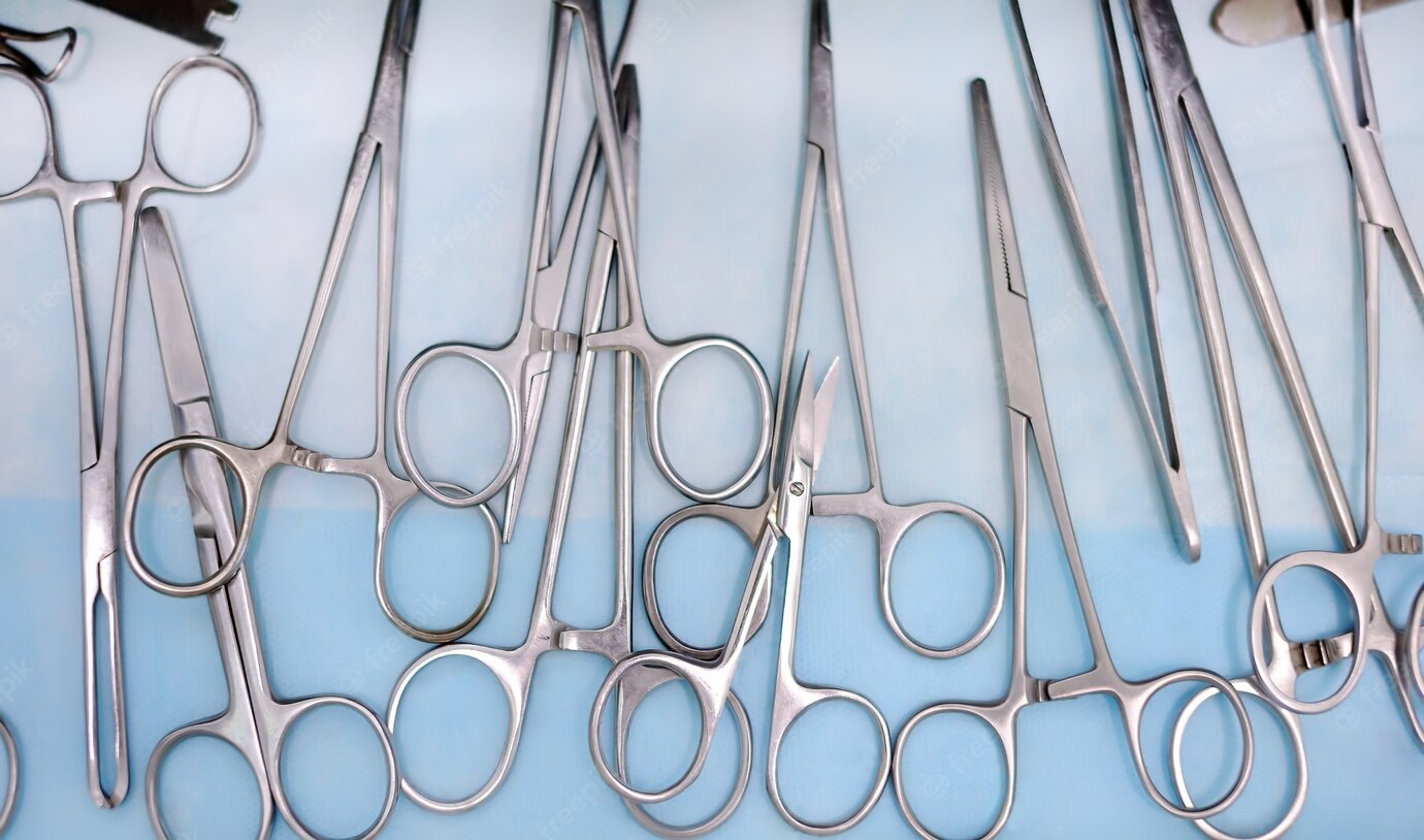 Surgeon using needle holder forceps during surgery